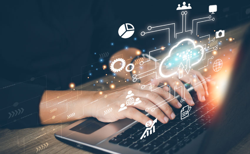 Mains sur clavier d’ordinateur ; éléments visuels (signes, mots, icônes) jaillissant pour illustrer la rédaction et le digital.