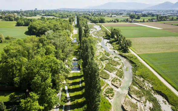 Photo drone : zone arborée traversée par une rivière, vue du ciel.